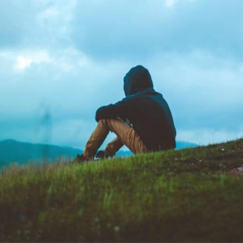 magányos férfi dombon ül